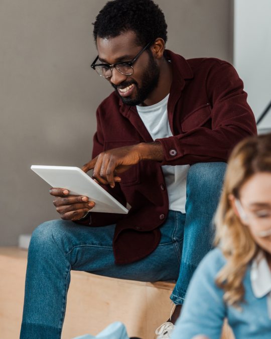 smiling-african-american-student-in-glasses-using-digital-tablet.jpg